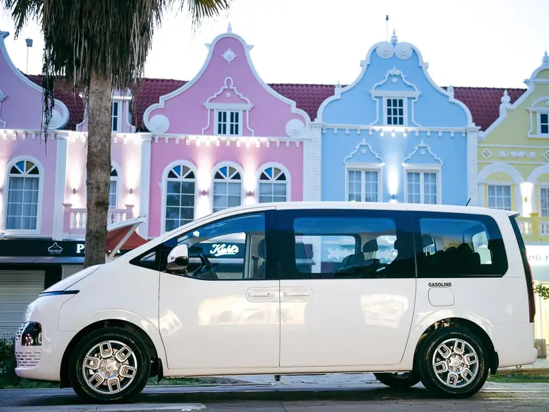 TRAC's Hyundai Staria van in front of Aruba's pastel Dutch colonial buildings