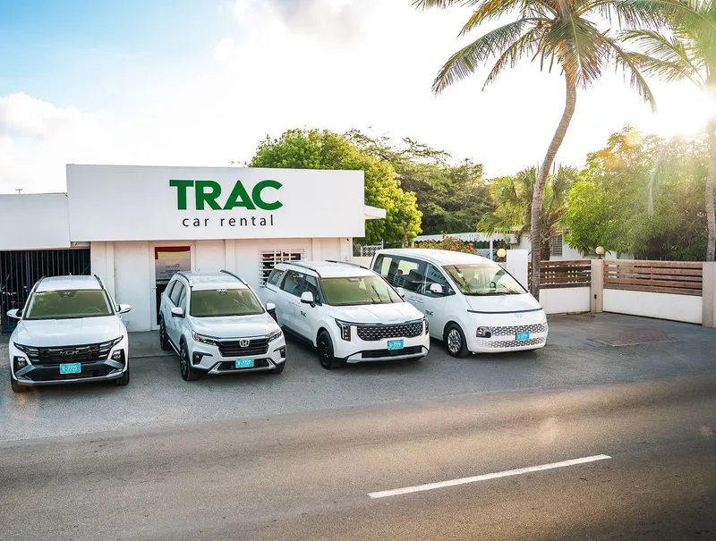 Four of TRAC's cars, a Hyundai Tucson, Honda BR-V, Kia Carnival and Hyundai Staria, in front of the TRAC Car Rental office